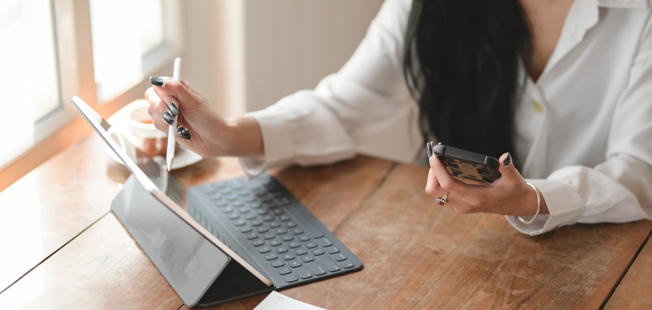 person using tablet with cell phone